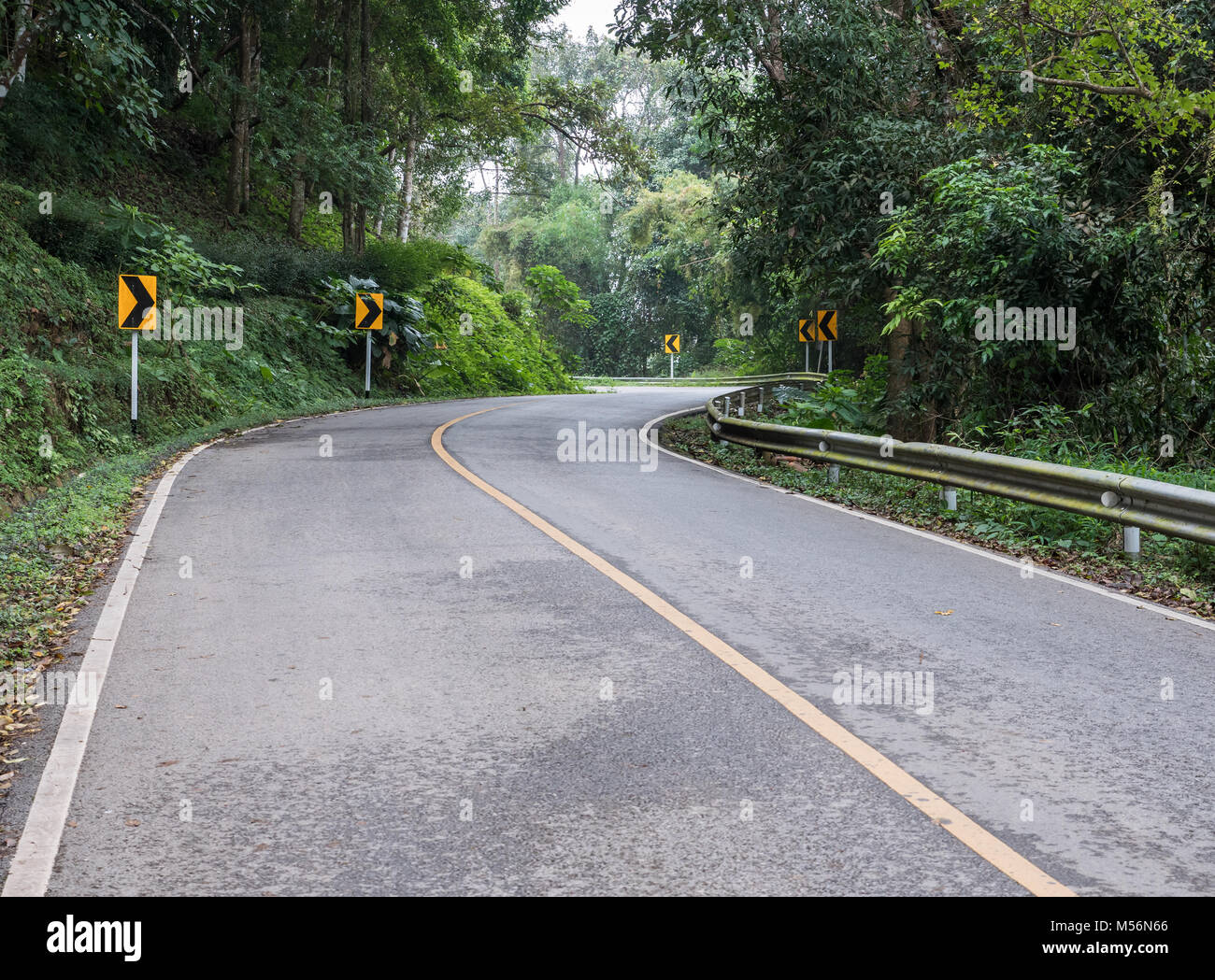 Curve asphalt road with the directional sign on the high mountain in ...
