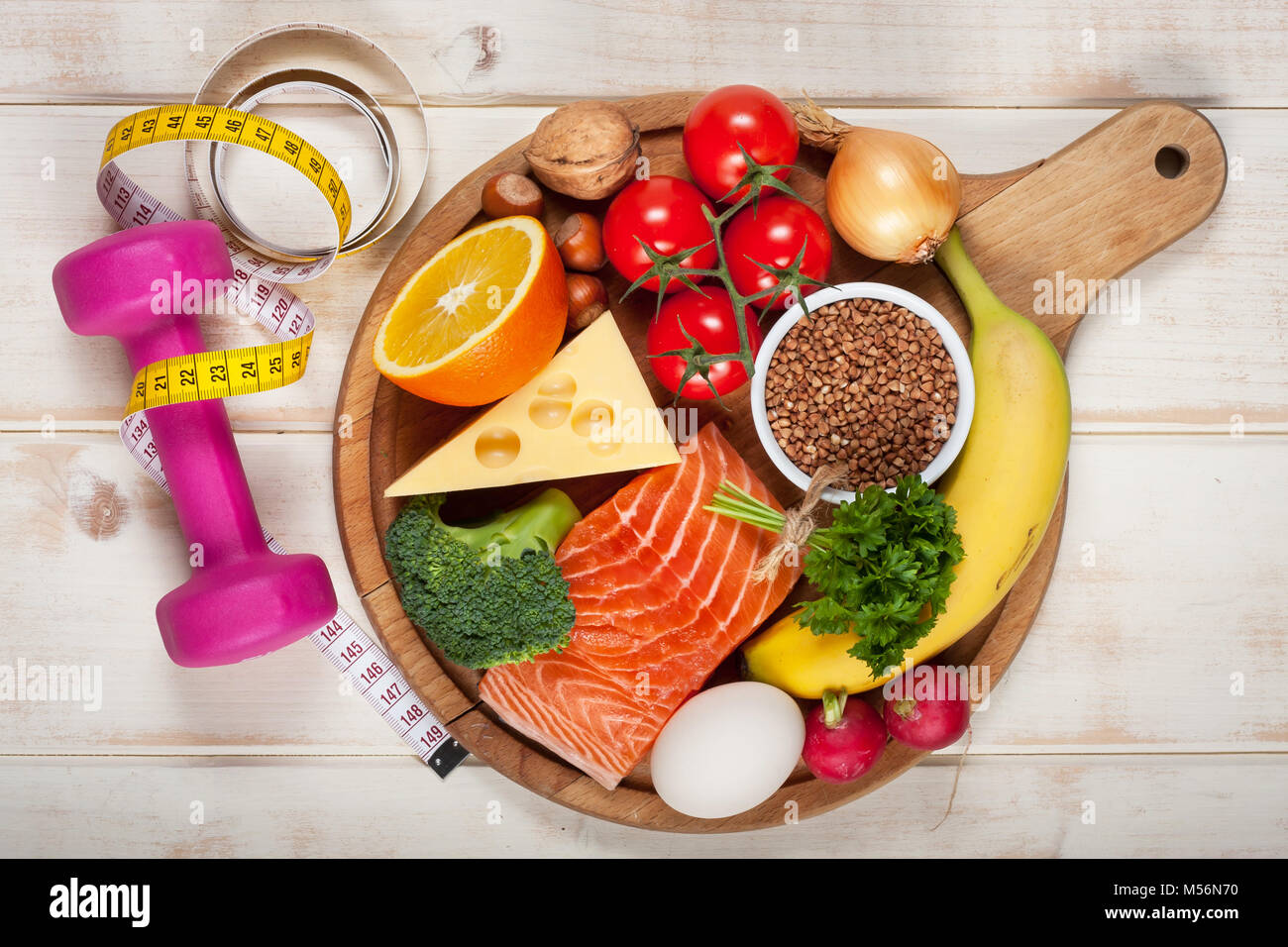 Healthy lifestyle concept. Dumbbell and healthy organic food on wooden table Stock Photo