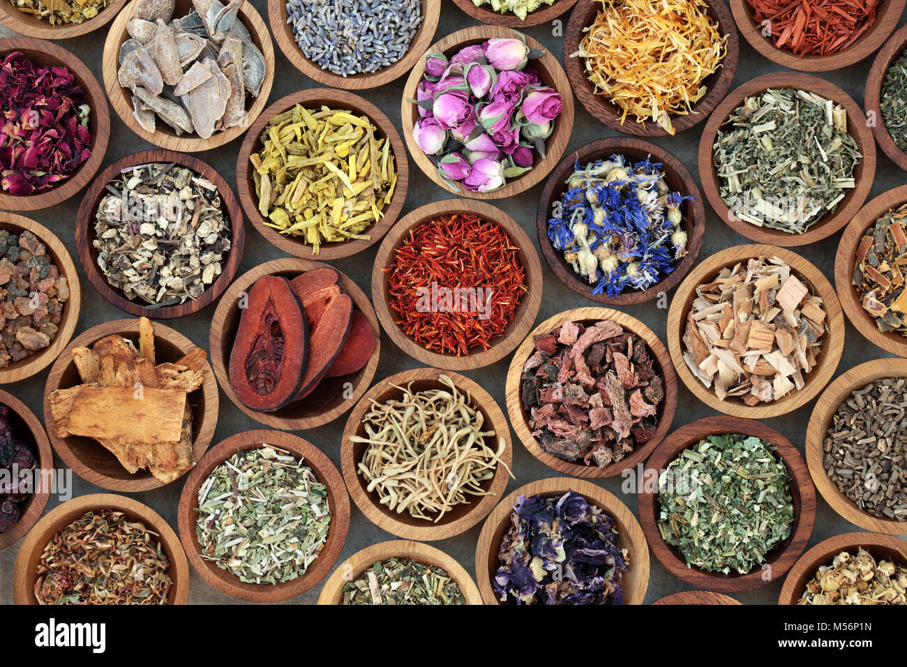 Herbal medicine used in alternative remedies with a variety of dried herbs and flowers in wooden bowls. Top view. Stock Photo