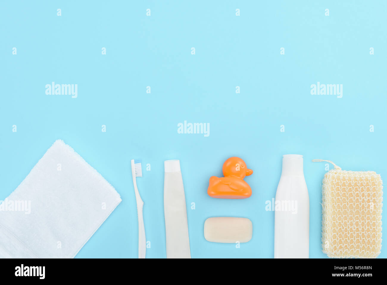 top view of body lotion, toothbrush, toothpaste, towel, soap and toy
