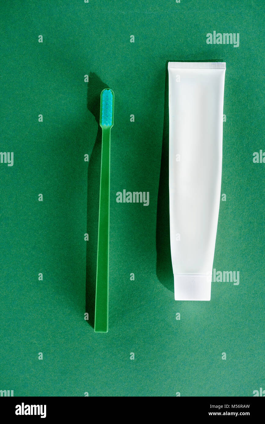 top view of toothbrush and tube of toothpaste, on green Stock Photo - Alamy
