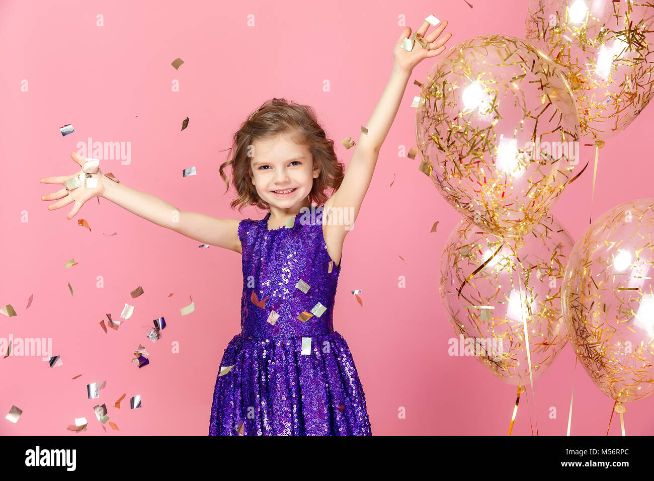 Happy girl in pink dress celebrating Stock Photo - Alamy