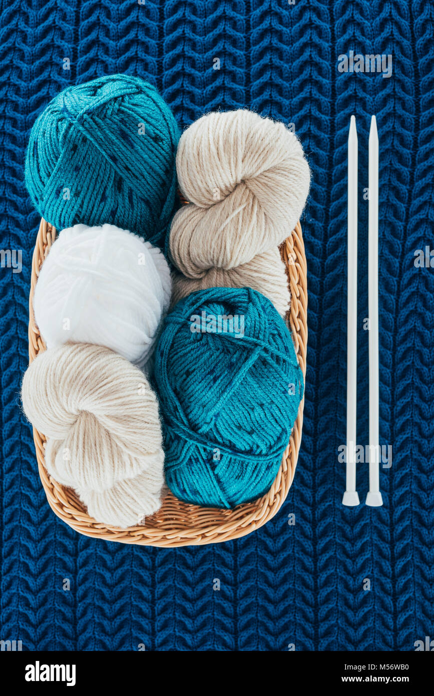 top view of different knitting yarn balls in wicker basket with ...