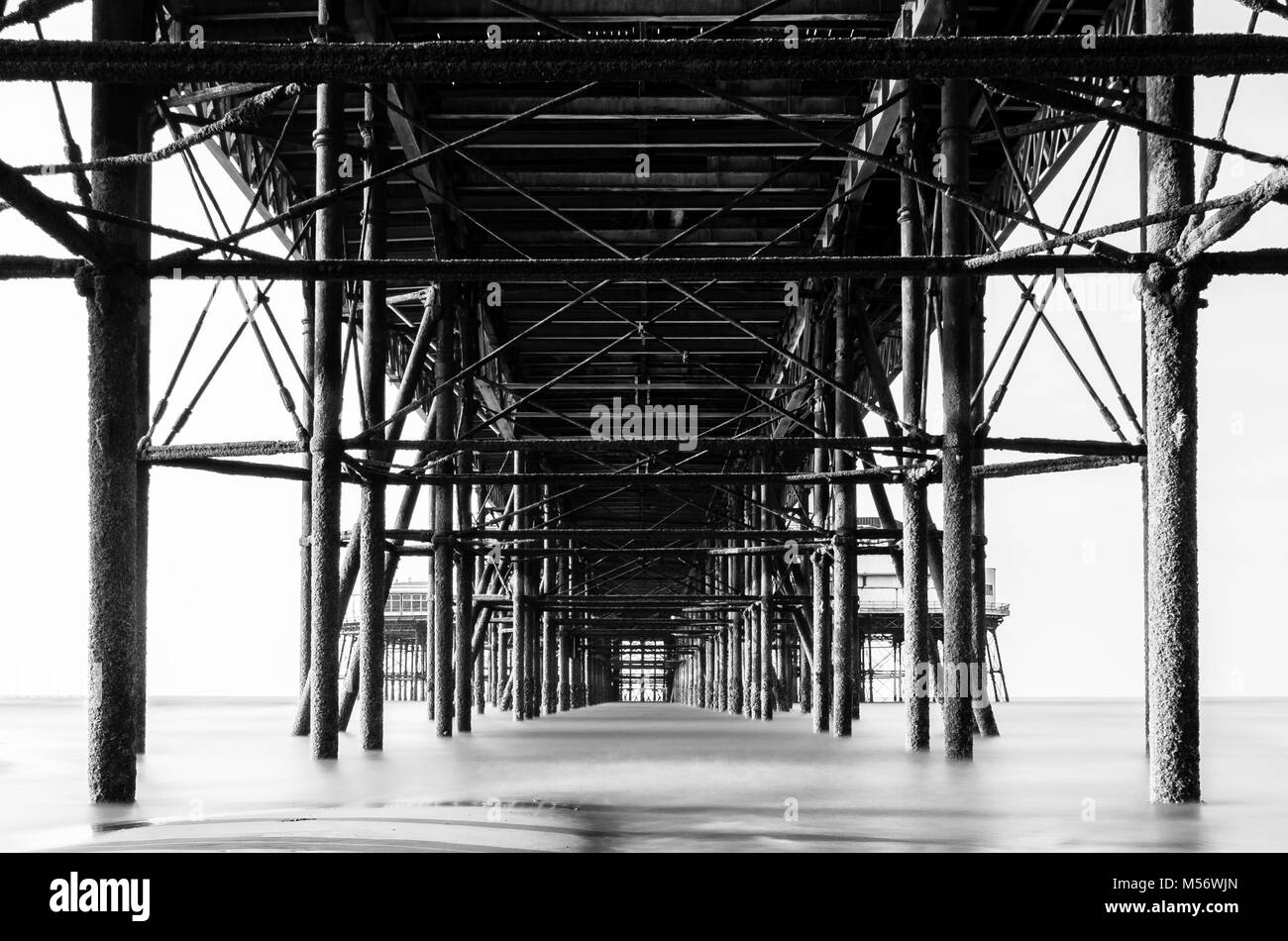 A black and white image of Blackpool north Pier view from the beach below Stock Photo