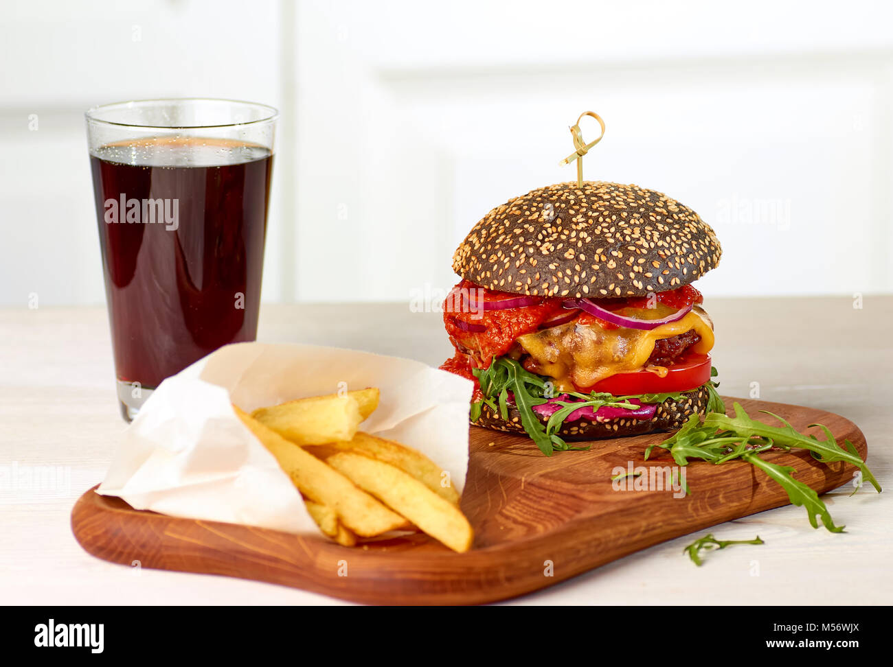 Black cheeseburger and chips with glass of cola Stock Photo