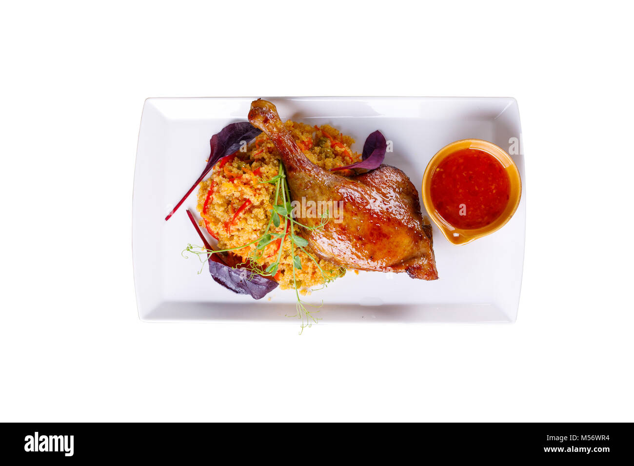 An original second dish from a chicken thigh with a mouth-watering garnish on a white background. Isolated. Stock Photo