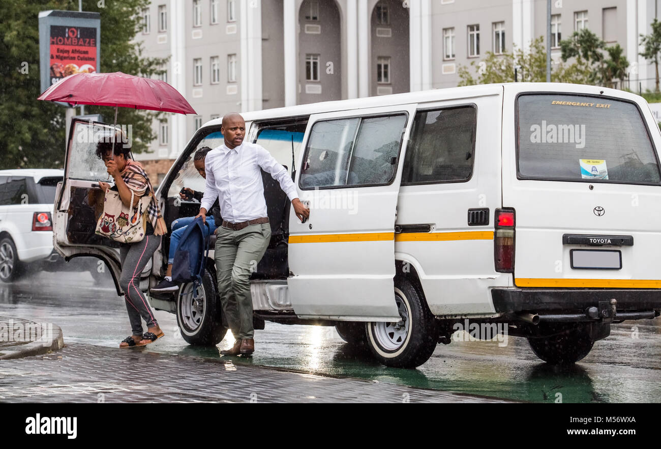 African people getting out of taxi in city center. Stock Photo