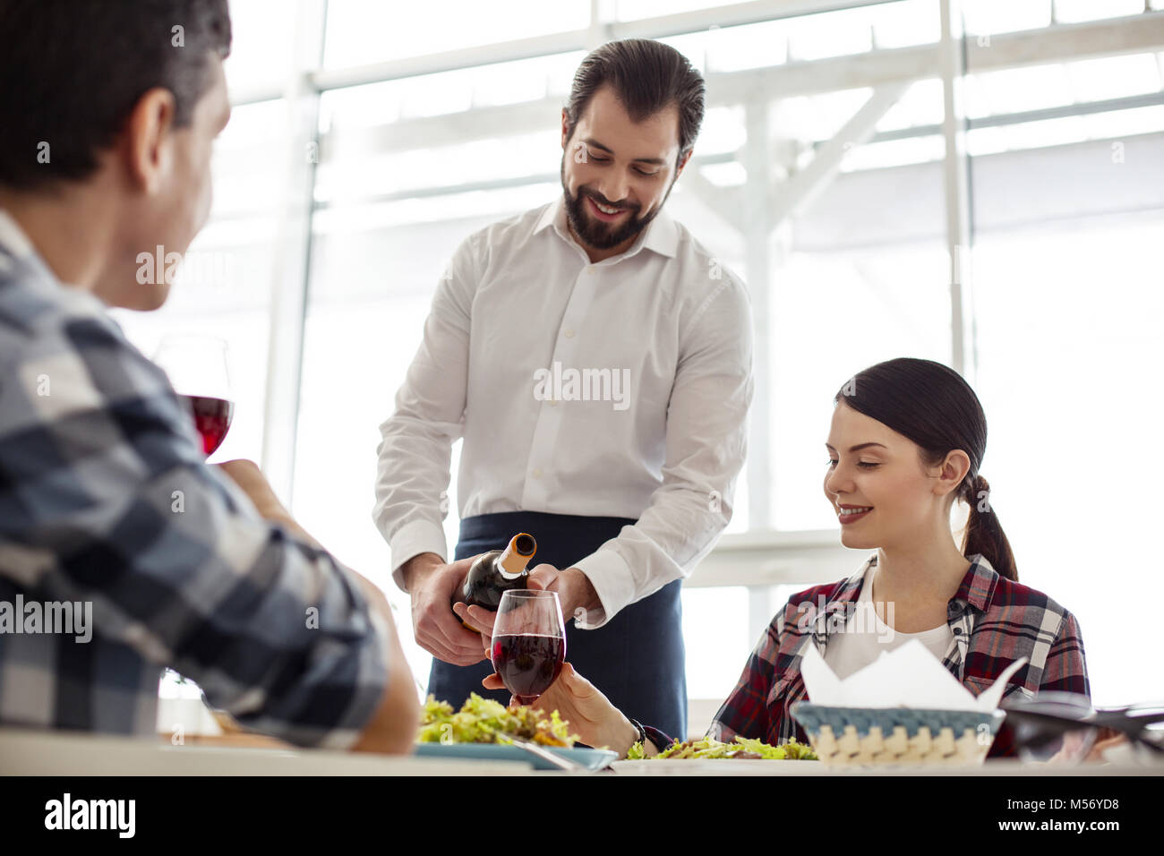 Exuberant nice waiter serving a table Stock Photo - Alamy