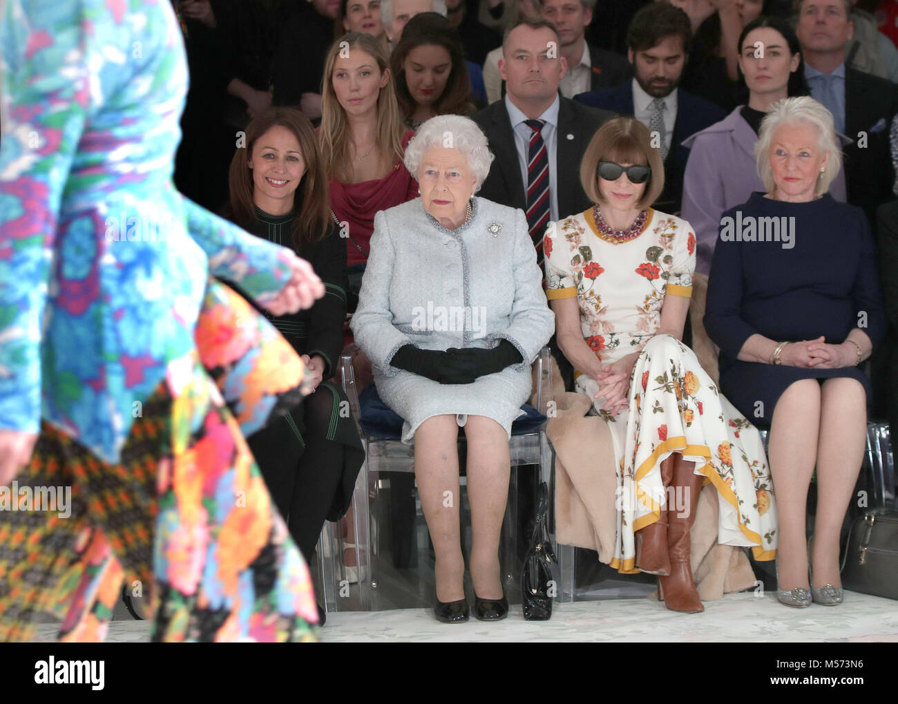Queen Elizabeth II sits with Anna Wintour (second right) and Caroline Rush (left), chief executive of the British Fashion Council (BFC) and royal dressmaker Angela Kelly (right), as they view Richard Quinn's runway show before presenting him with the inaugural Queen Elizabeth II Award for British Design as she visits London Fashion Week's BFC Show Space in central London. Stock Photo