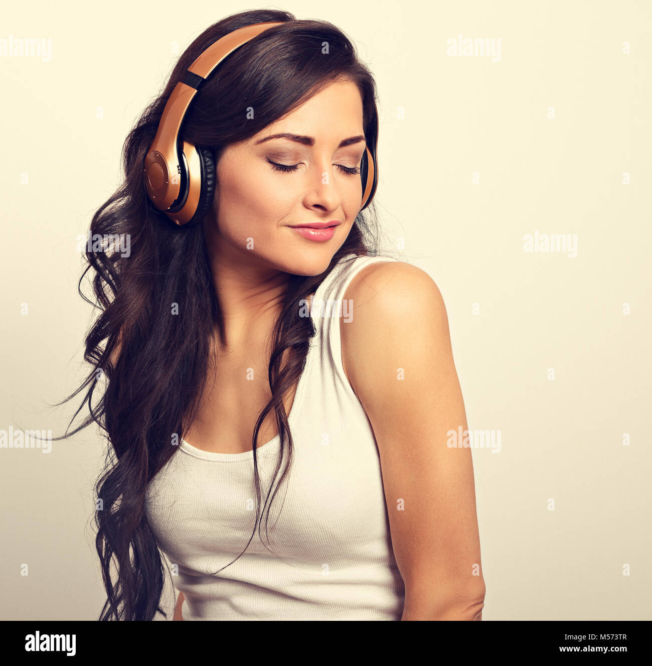 Beautiful happy long hair young woman in casual clothing listening the ...