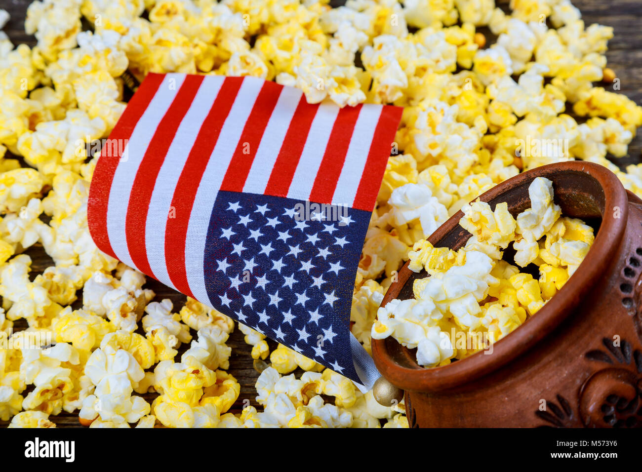 Salty popcorn in a wooden cup American flag flying, flag USA is on a