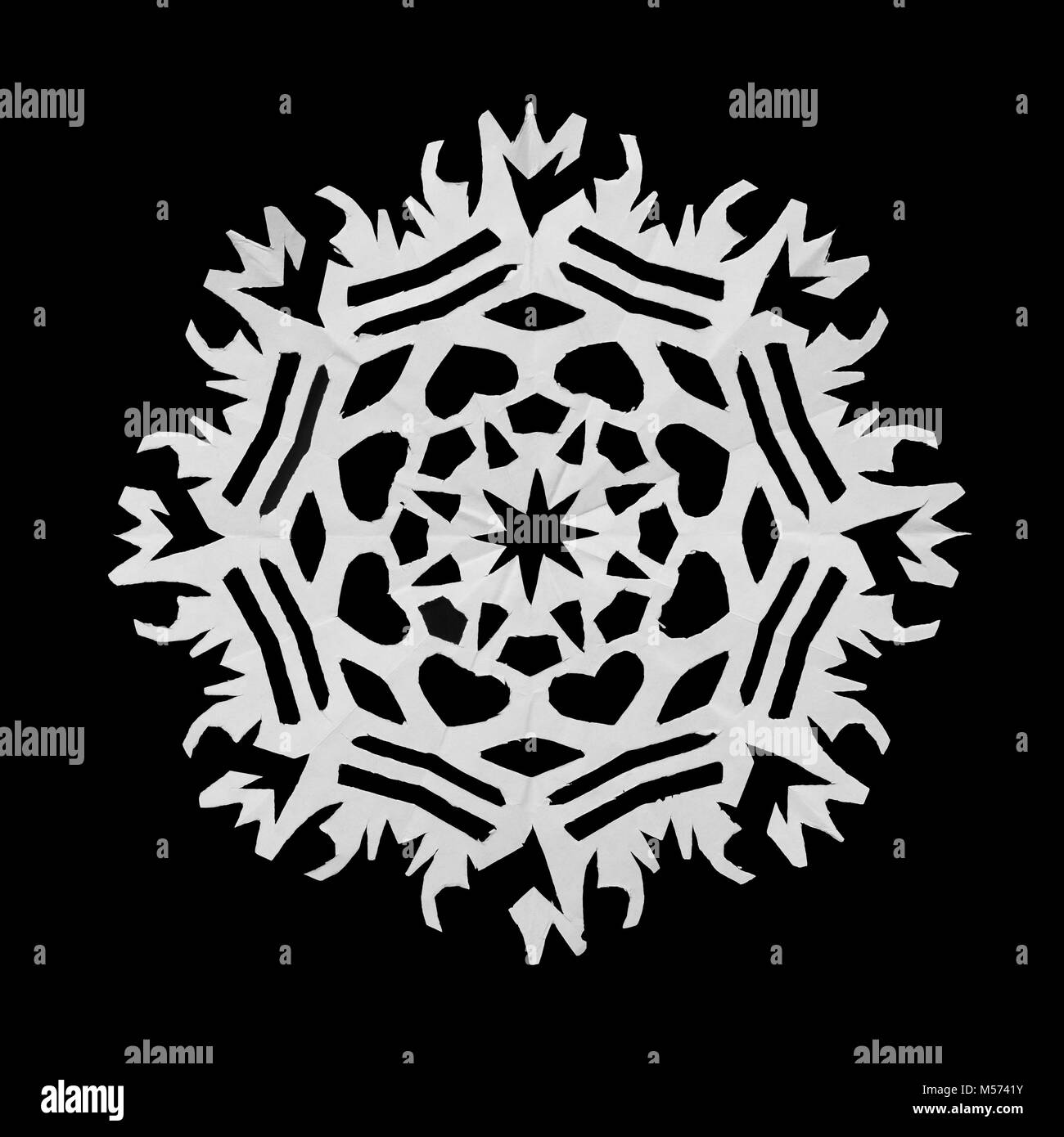 On a black background lie a paper snowflake, cut from paper Stock Photo ...