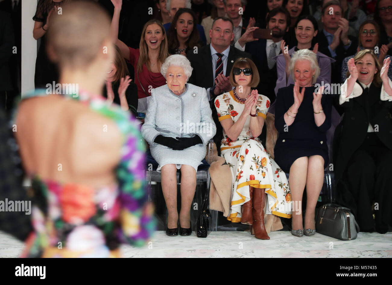Queen Elizabeth II sits with Anna Wintour (third right) and Caroline Rush, chief executive of the British Fashion Council (BFC) (partially hidden left) and royal dressmaker Angela Kelly (second right), as they view Richard Quinn's runway show before presenting him with the inaugural Queen Elizabeth II Award for British Design as she visits London Fashion Week's BFC Show Space in central London. Stock Photo