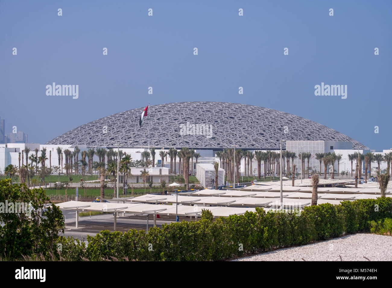 Louvre Abu Dhabi, Distant Shot with UAE Flag waving. Stock Photo