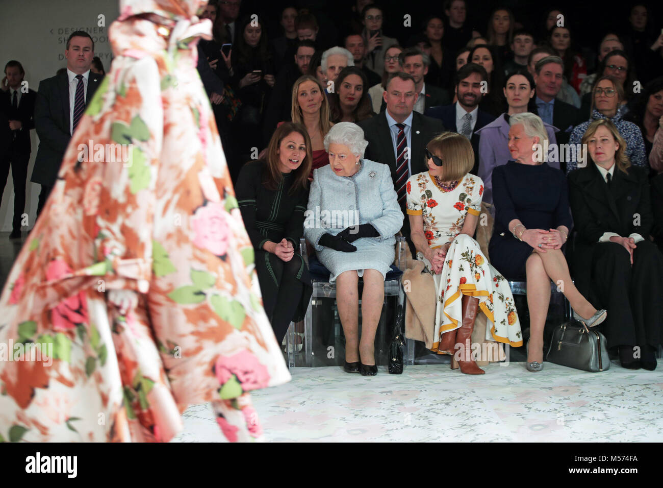 Queen Elizabeth II sits with Anna Wintour (third left), Caroline Rush (left), chief executive of the British Fashion Council (BFC) and royal dressmaker Angela Kelly (fourth left), as they view Richard Quinn's runway show before presenting him with the inaugural Queen Elizabeth II Award for British Design as she visits London Fashion Week's BFC Show Space in central London. Stock Photo