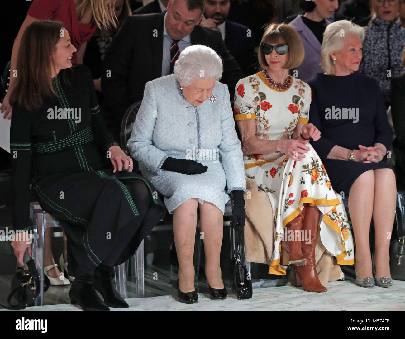 Queen Elizabeth II sits with Anna Wintour (second right), Caroline Rush (left), chief executive of the British Fashion Council (BFC) and royal dressmaker Angela Kelly (right), as they view Richard Quinn's runway show before presenting him with the inaugural Queen Elizabeth II Award for British Design as she visits London Fashion Week's BFC Show Space in central London. Stock Photo