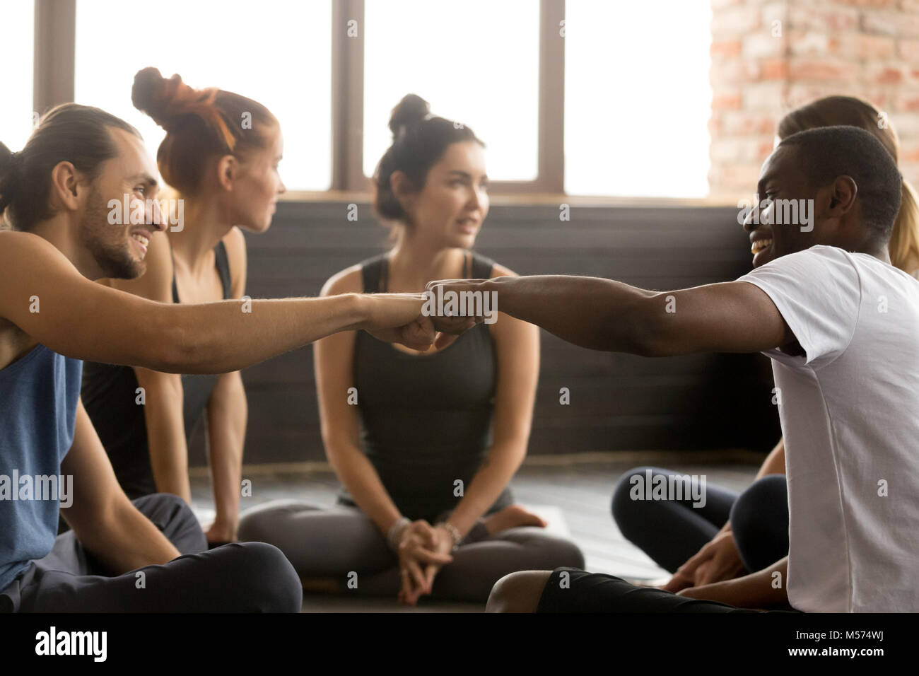 African american and caucasian men fist bumping at group trainin Stock Photo