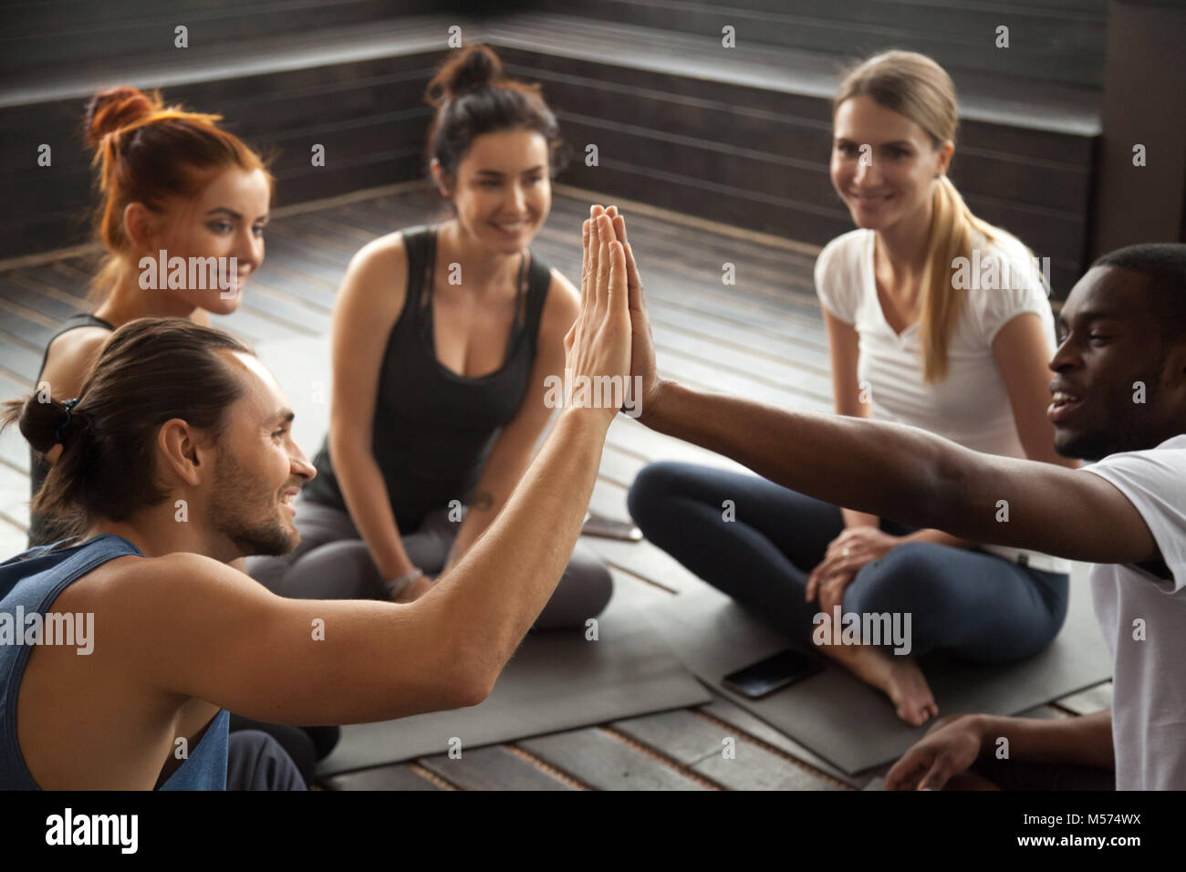 Smiling african and caucasian men giving high-five at group trai Stock Photo