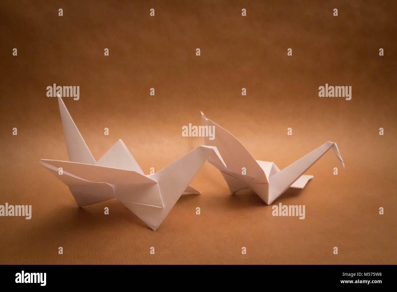 two 2  white bird origami brown background Stock Photo