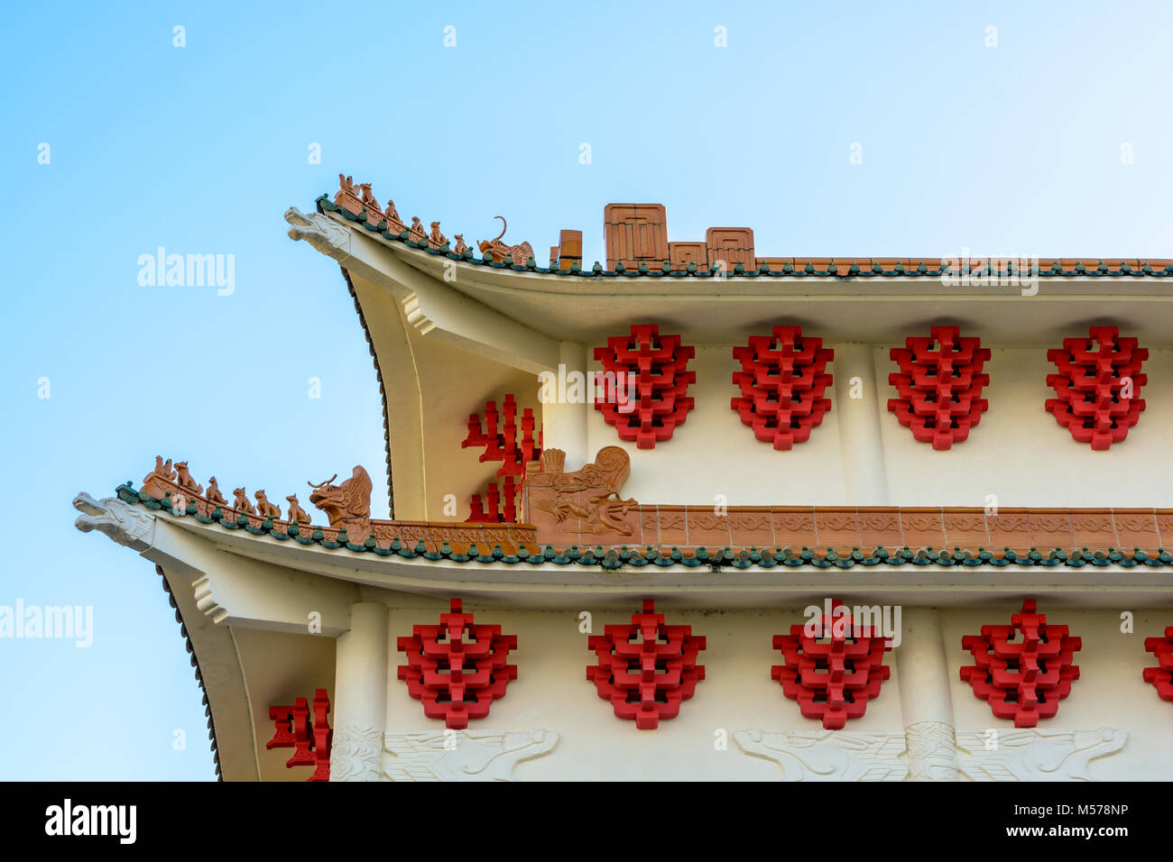 Modern building with chinese-inspired architecture featuring curved roofs, ridges decorated with ceramic figurines, dragon shaped beams, glazed roof t Stock Photo