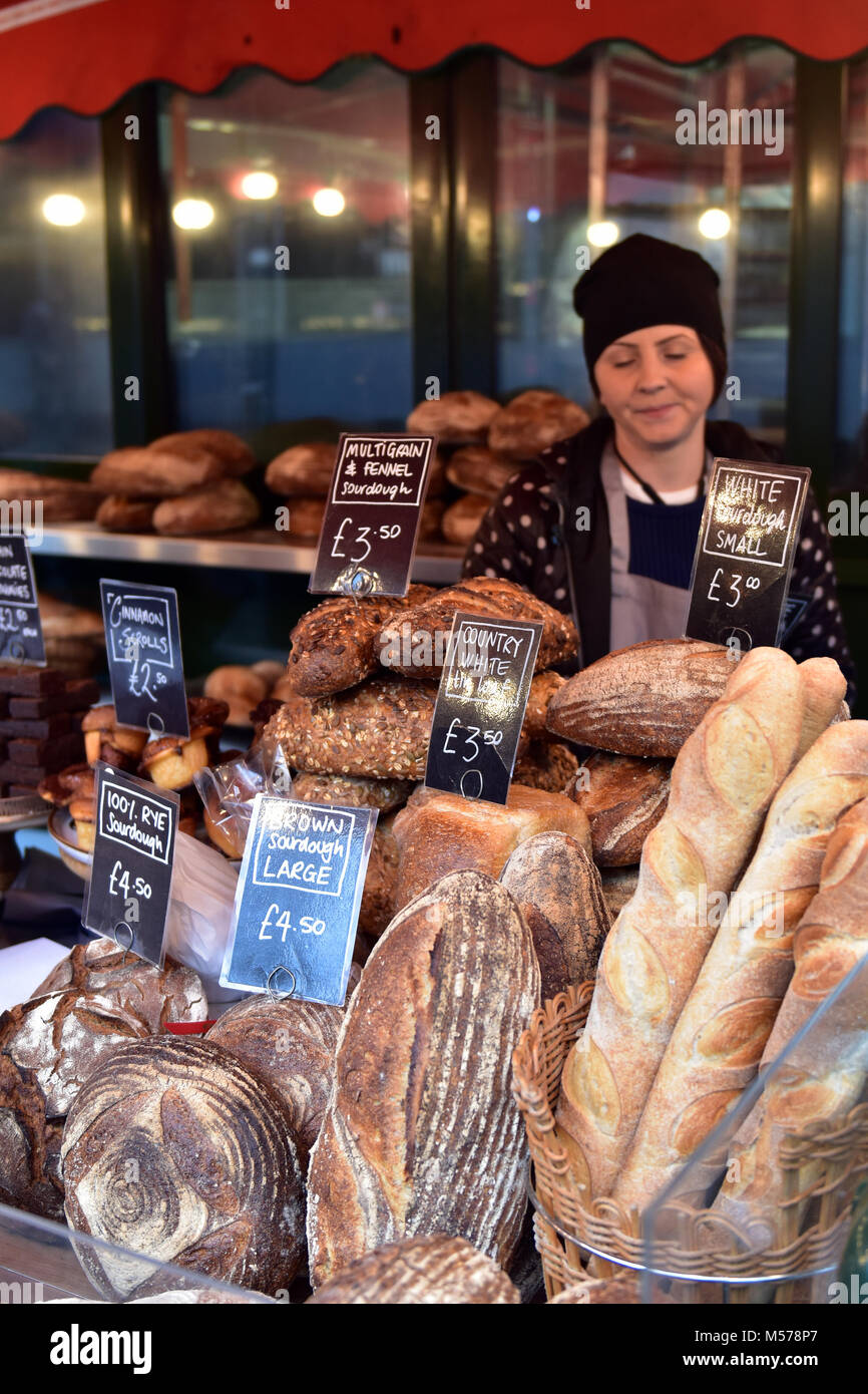 An artisan bakery or bread selling stall at borough market in the centre of london uk. Baking and bakers bespoke tasty delicatessen bread and loaves. Stock Photo