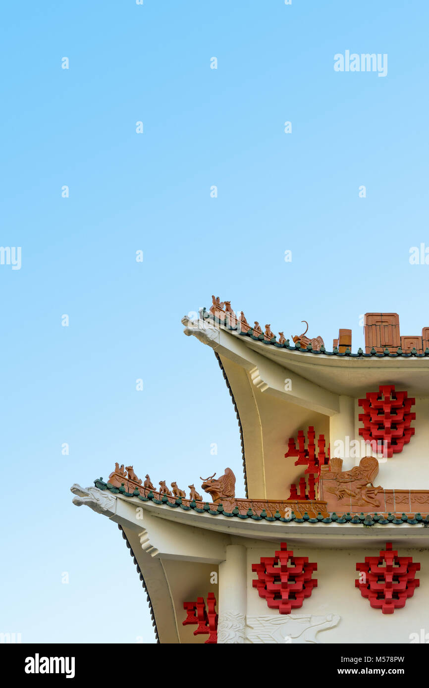 Modern building with chinese-inspired architecture featuring curved roofs, ridges decorated with ceramic figurines, dragon shaped beams, glazed roof t Stock Photo