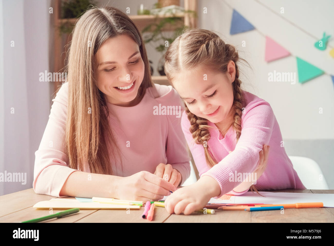 Mother and daughter weekend together at home drawing with pencils close ...