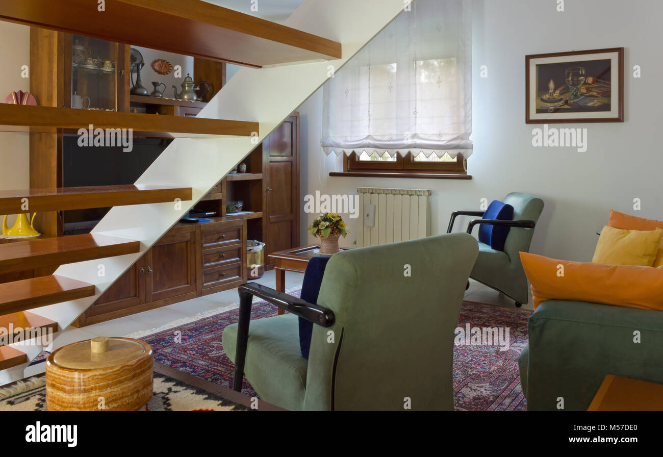 Italian classic living room beside a wooden staircase Stock Photo - Alamy