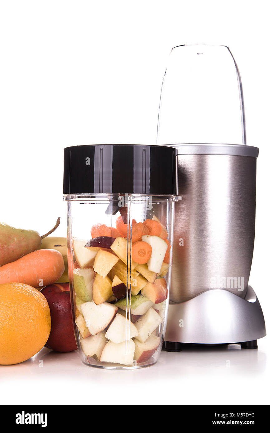 Healthy fruits with small blender on a cutting board getting ready for