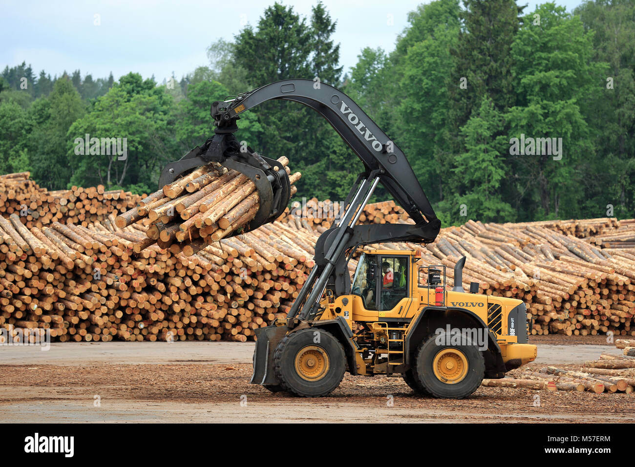 KYRO, FINLAND - JUNE 7, 2014: Volvo L180F High Lift wheel loader working at sawmill lumber yard.  The arm is capable of reaching a lift height of 5.8  Stock Photo
