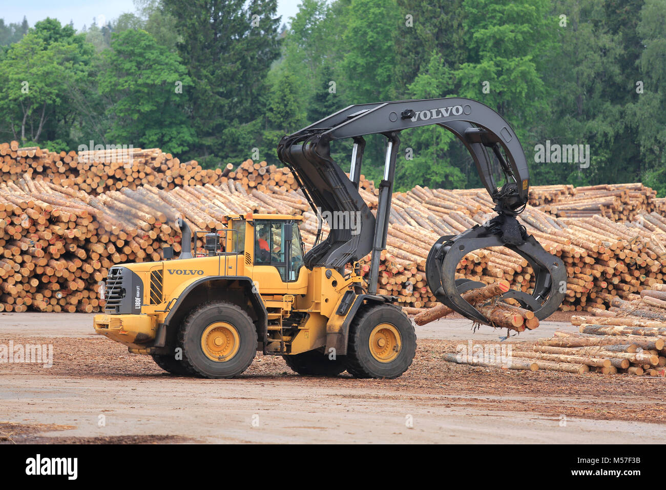 KYRO, FINLAND - JUNE 7, 2014: Volvo L180F High Lift wheel loader working at sawmill lumber yard.  The L180F has a new lift arm design for improved lif Stock Photo