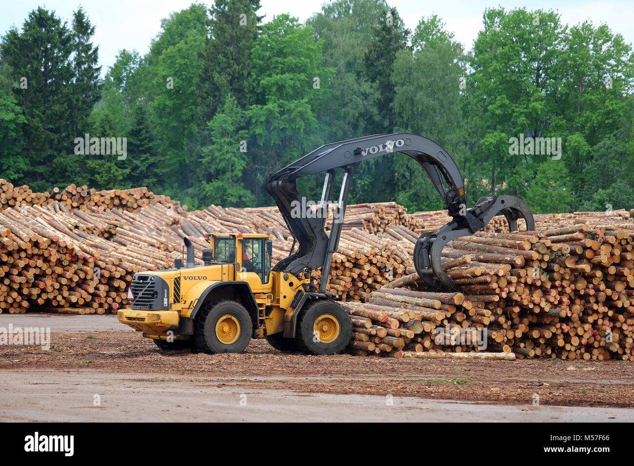 KYRO, FINLAND - JUNE 7, 2014: Volvo L180F High Lift wheel loader working at sawmill lumber yard.  The arm is capable of reaching a lift height of 5.8  Stock Photo