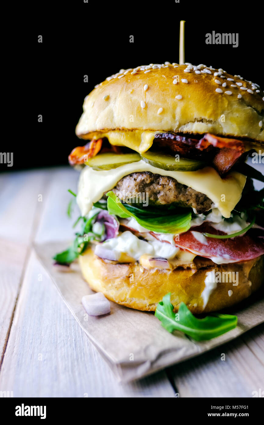 Appetizing cheeseburger on wooden table. Stock Photo
