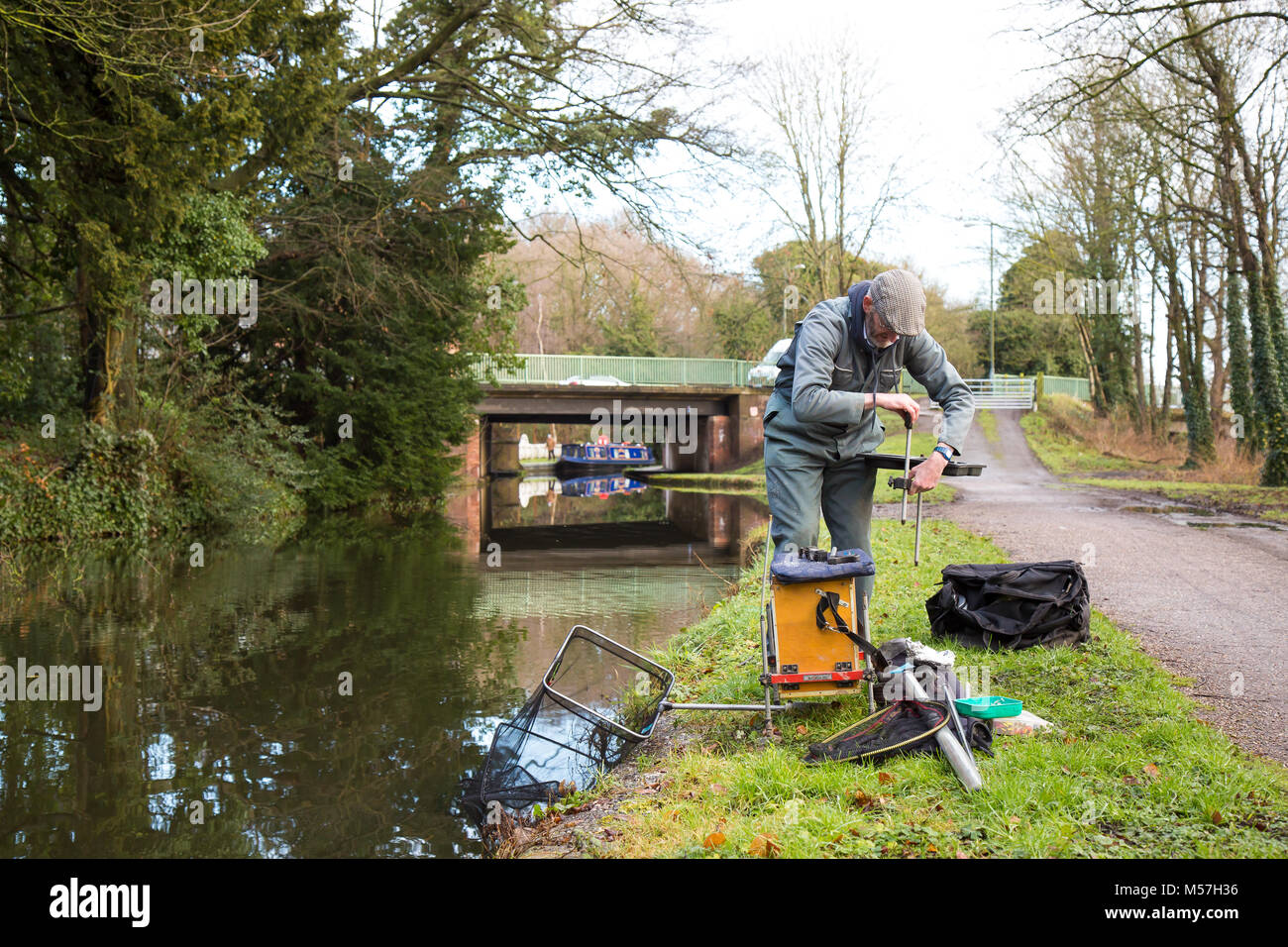 Lone fisherman putting away his tackle isolated on towpath after morning's fishing in UK canal. Angling UK. Stock Photo