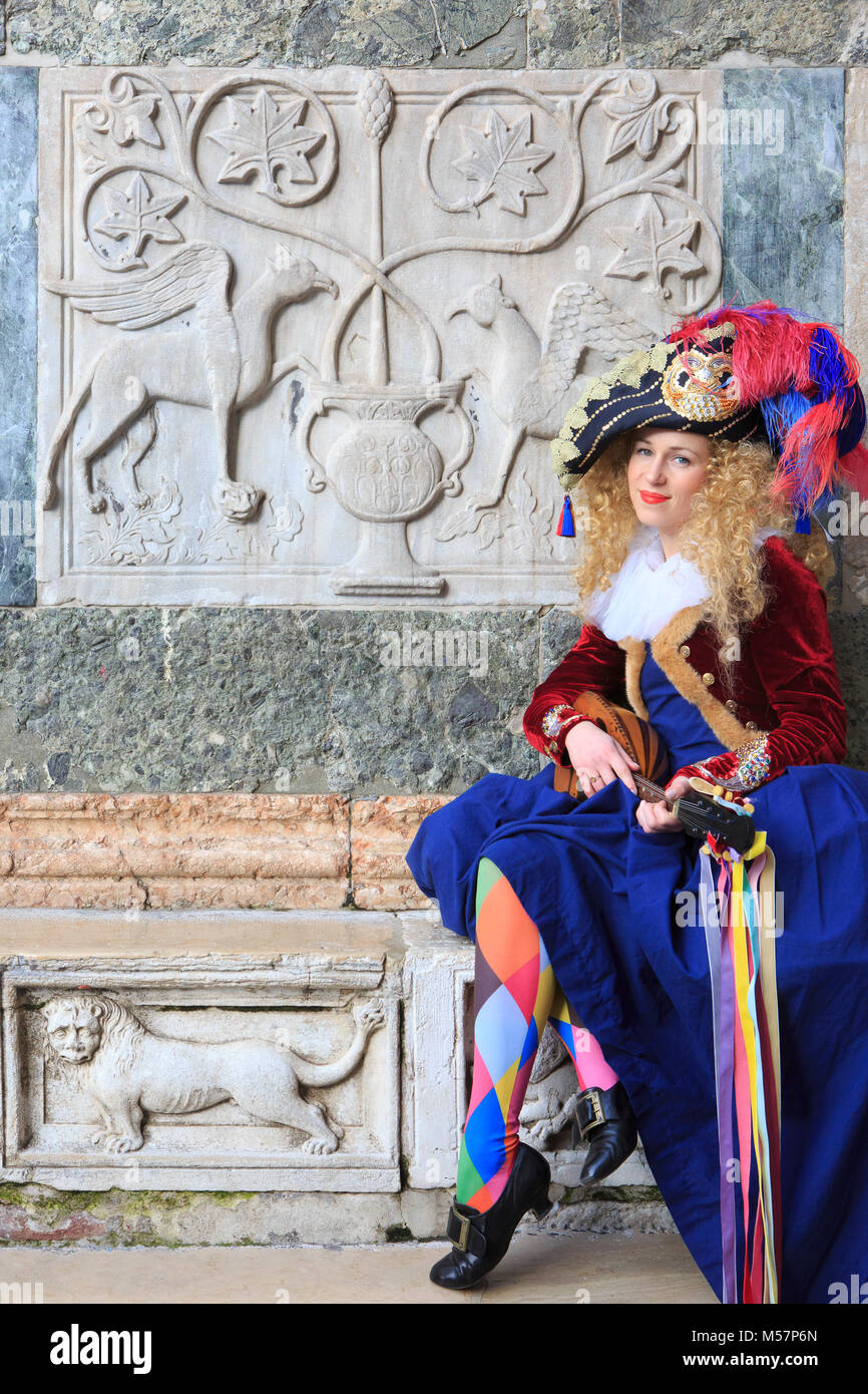 A beautiful harlequin playing the mandolin outside Saint Mark's Basilica during the Carnivel of Venice (Carnevale di Venezia) in Venice, Italy Stock Photo