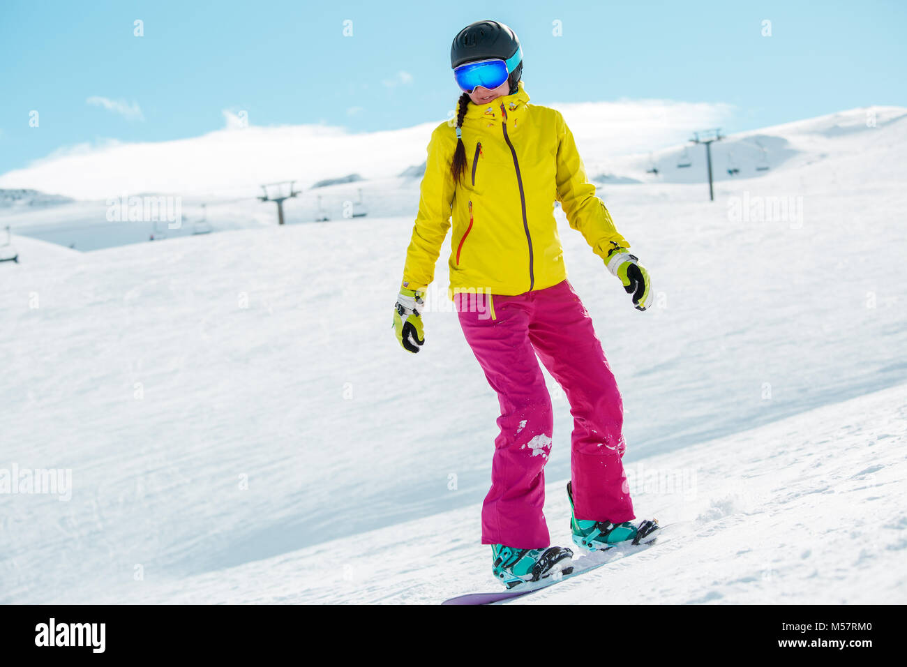 Picture of young athlete girl wearing helmet in sports clothes snowboarding Stock Photo