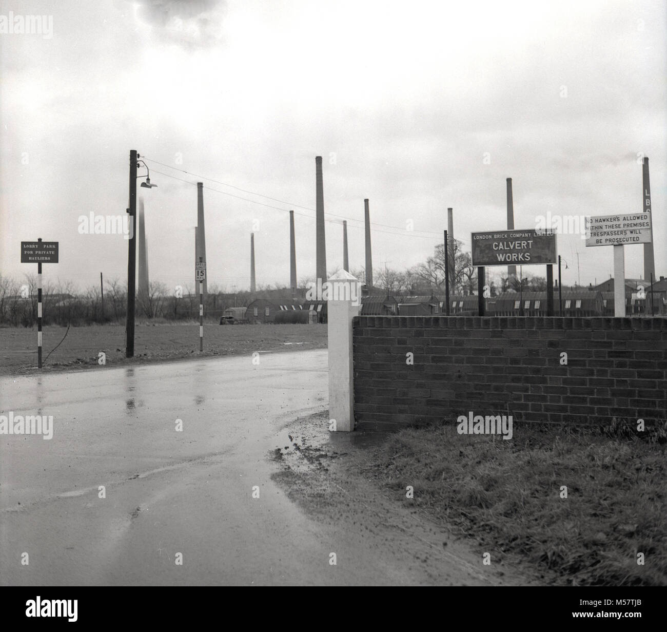 Mid-1950s, historical picture showing the entrance to the Calverts Works, the Buckinghamshire site of the the brickmakers, the London Brick Company. Founded in 1900 by Arthur Werner Ltter, it survived for nearly 100 years before closing in 1991. The large chimneys and numerous works nissan huts can be seen in the picture. Stock Photo