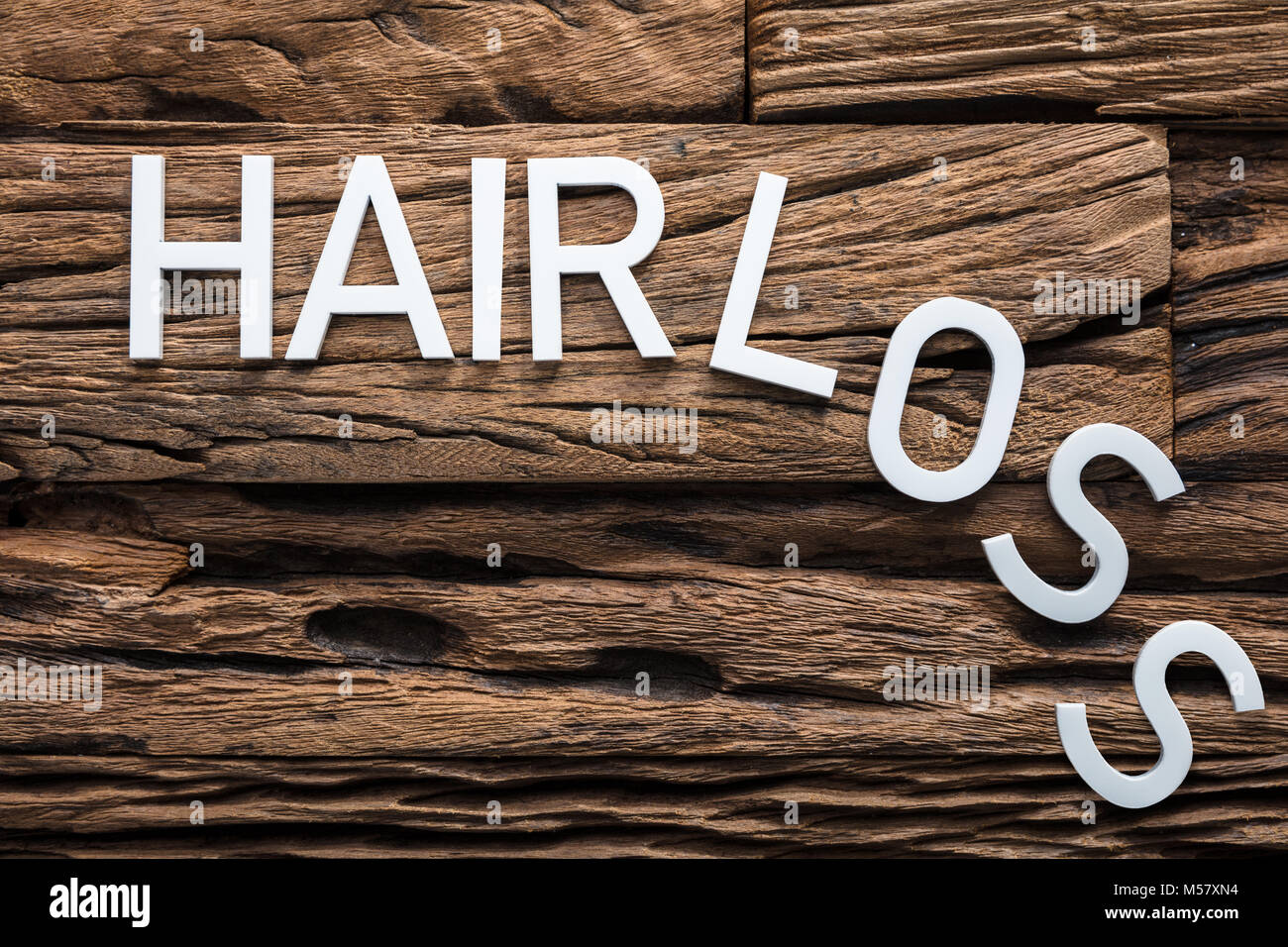 Closeup of white hair loss text on wood Stock Photo