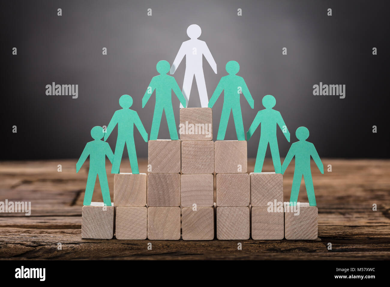 Closeup of paper boss with employees standing on wooden blocks Stock Photo