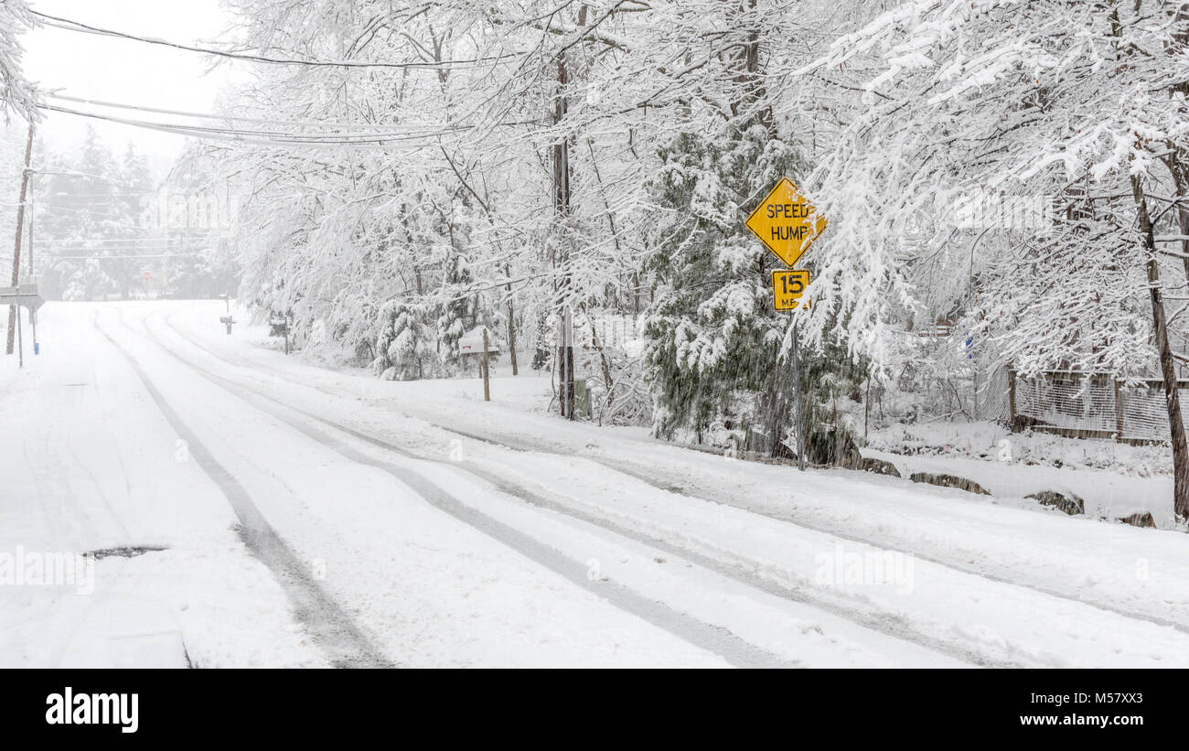 Speed bump warning signon street in snow storm Stock Photo - Alamy