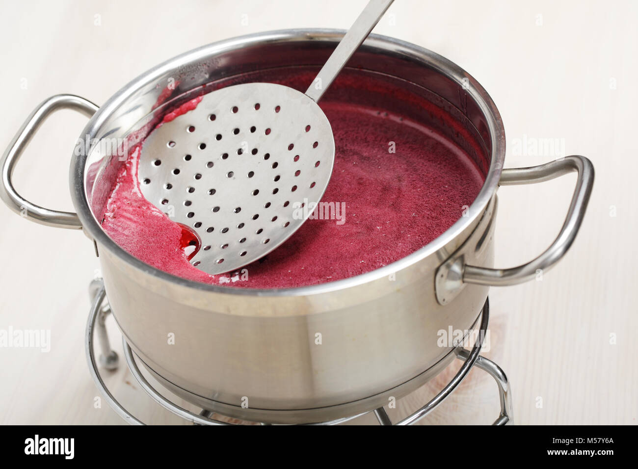Skimming the foam using a slotted spoon Stock Photo Alamy