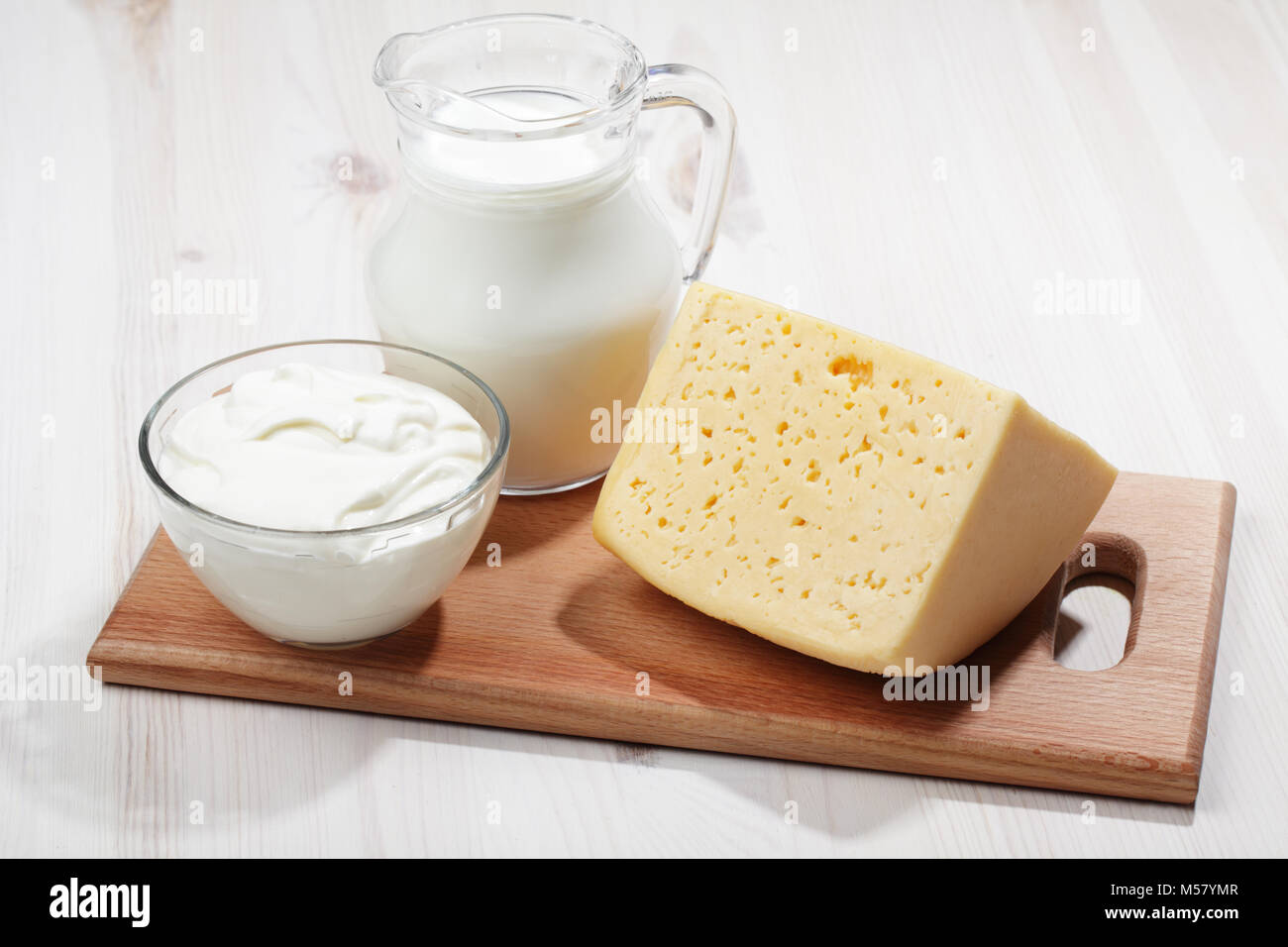 Milk, sour cream, and a segment of cheese Stock Photo
