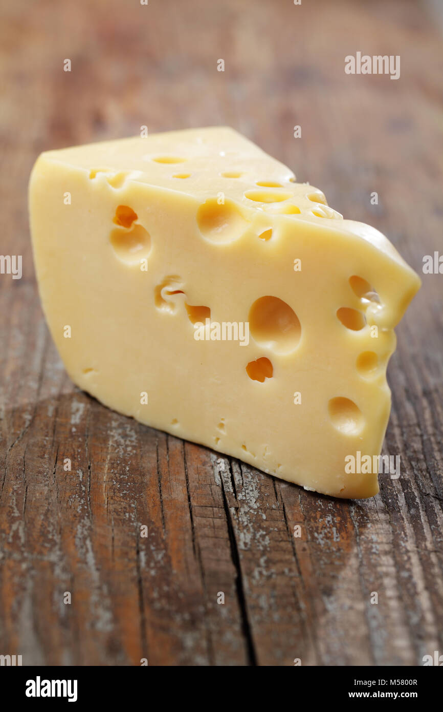 Piece of yellow cheese with big holes Stock Photo Alamy