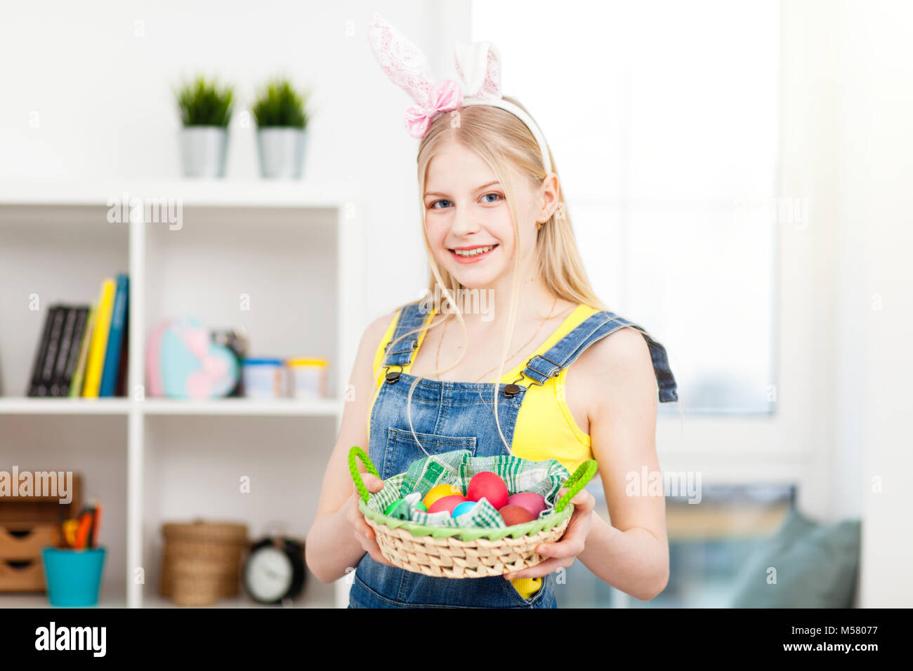 Teenage girl wearing bunny ears holding Easter eggs Stock Photo - Alamy