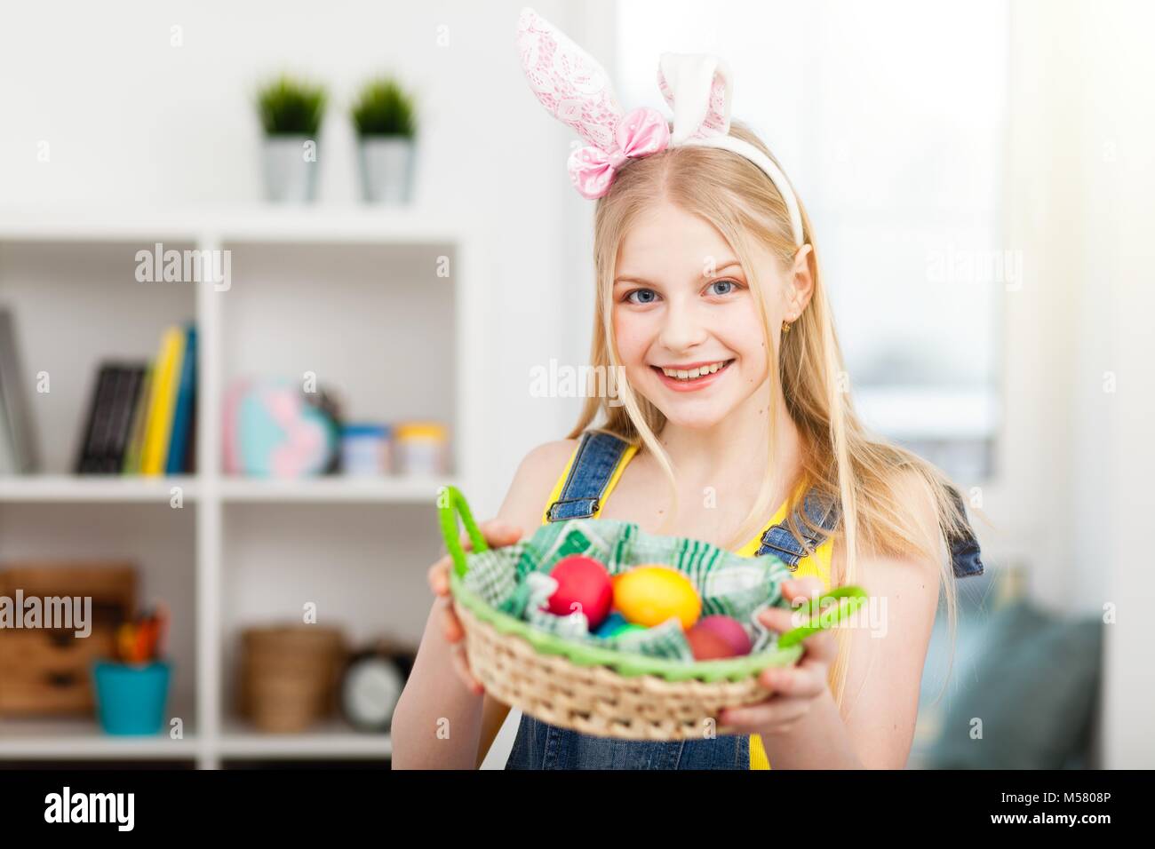 Teenage girl wearing bunny ears holding Easter eggs Stock Photo - Alamy