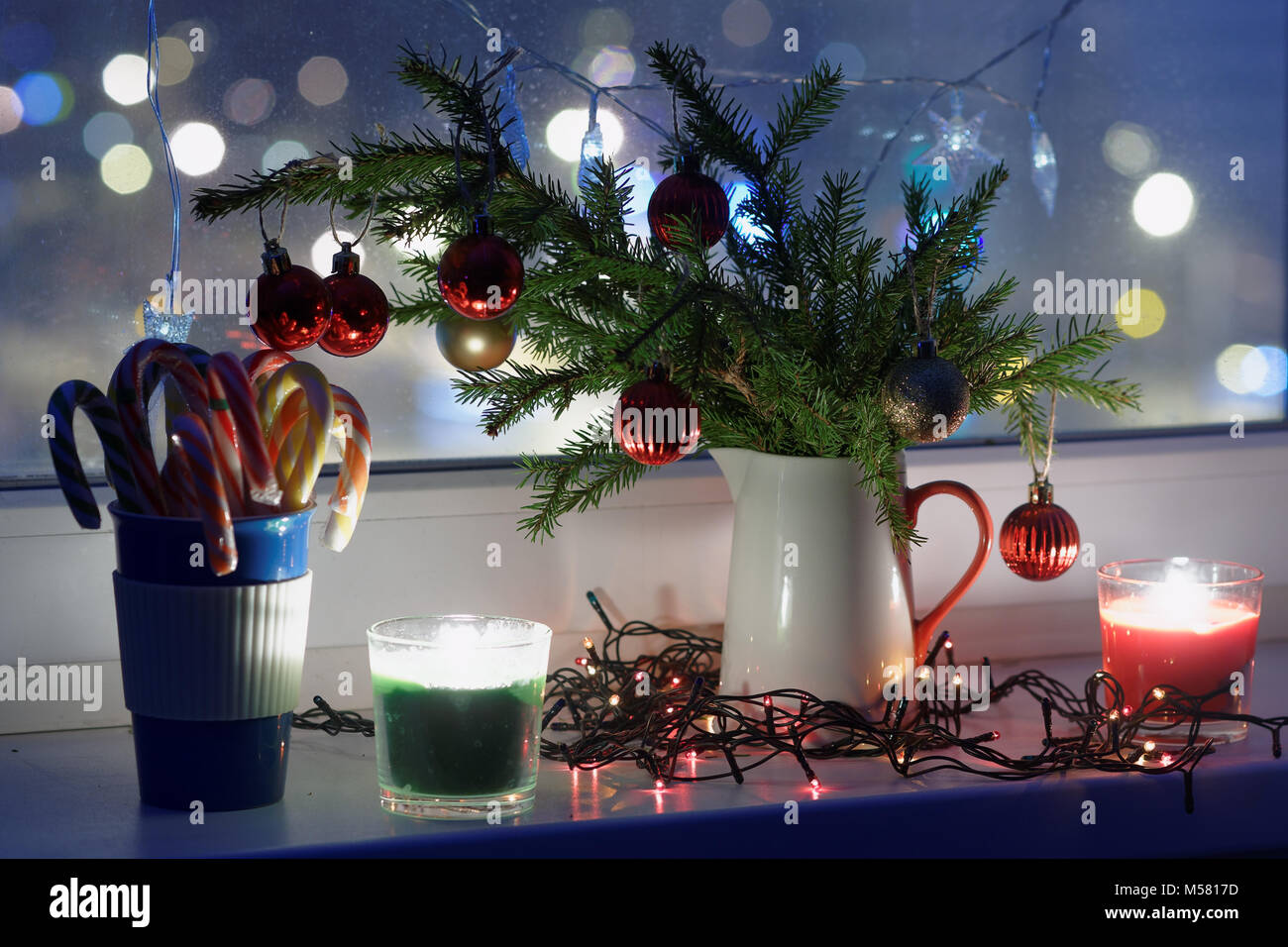 Christmas decorations and candles on a window sill Stock Photo