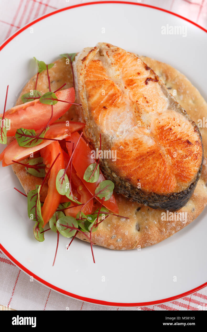 Roasted salmon steak with vegetables on a Finnish flatbread Stock Photo