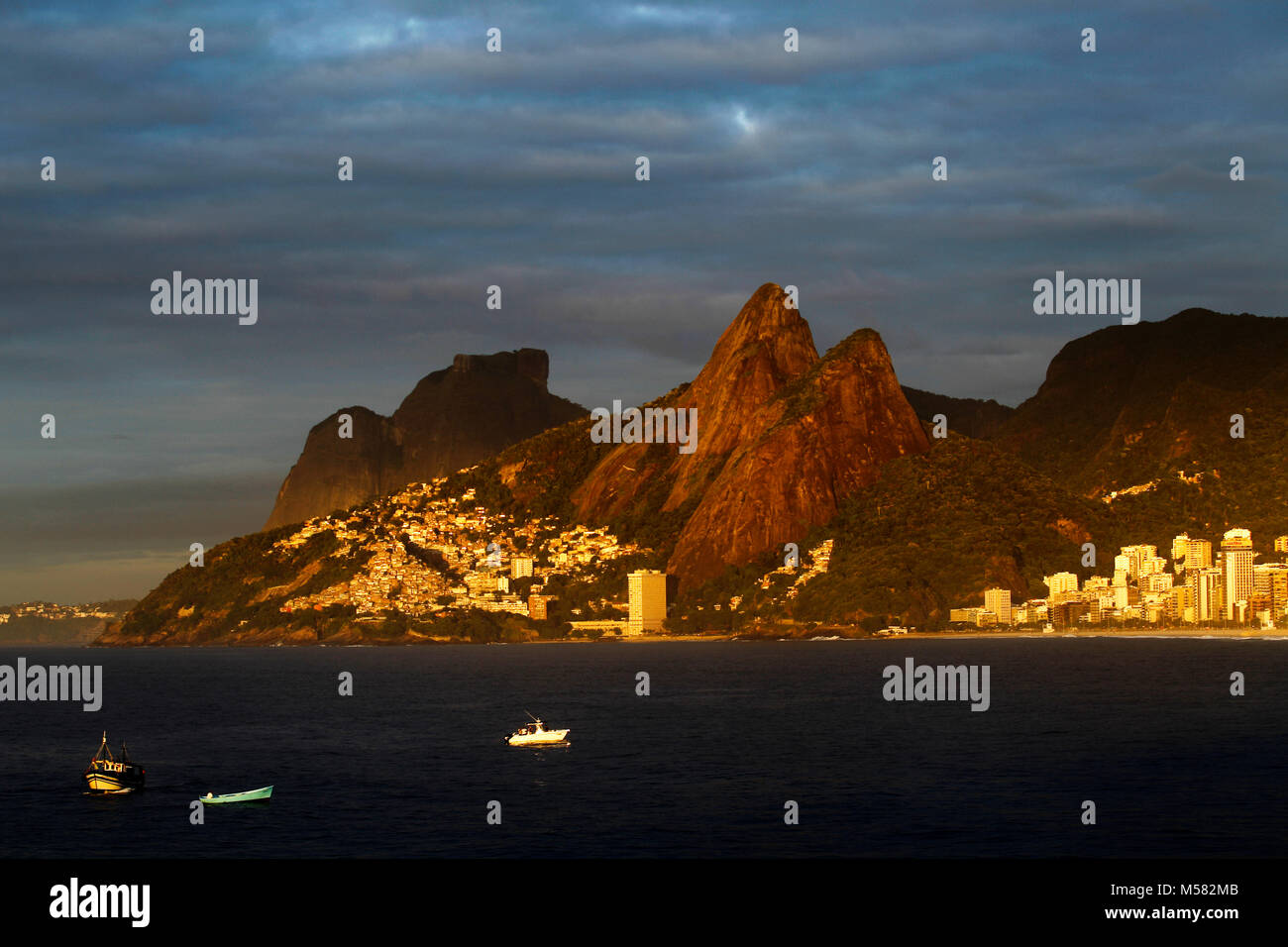 Early morning fishermans boats at ipanema beach, with Two Brother Hills, Pedra da Gavea and Vidigal favela in the background, Rio de Janeiro, Brazil Stock Photo