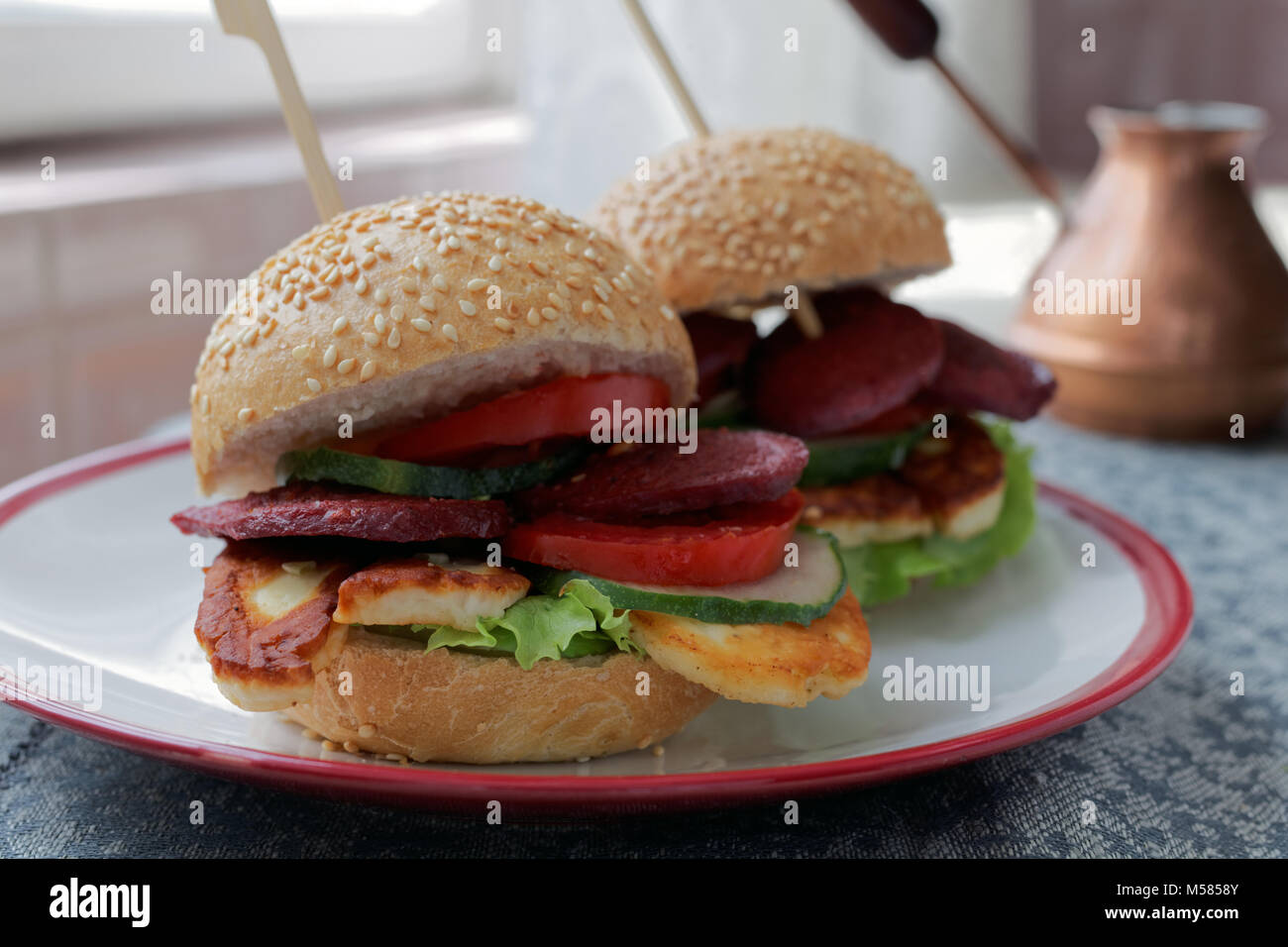 Turkish burgers with sucuk, halloumi cheese, and vegetables Stock Photo