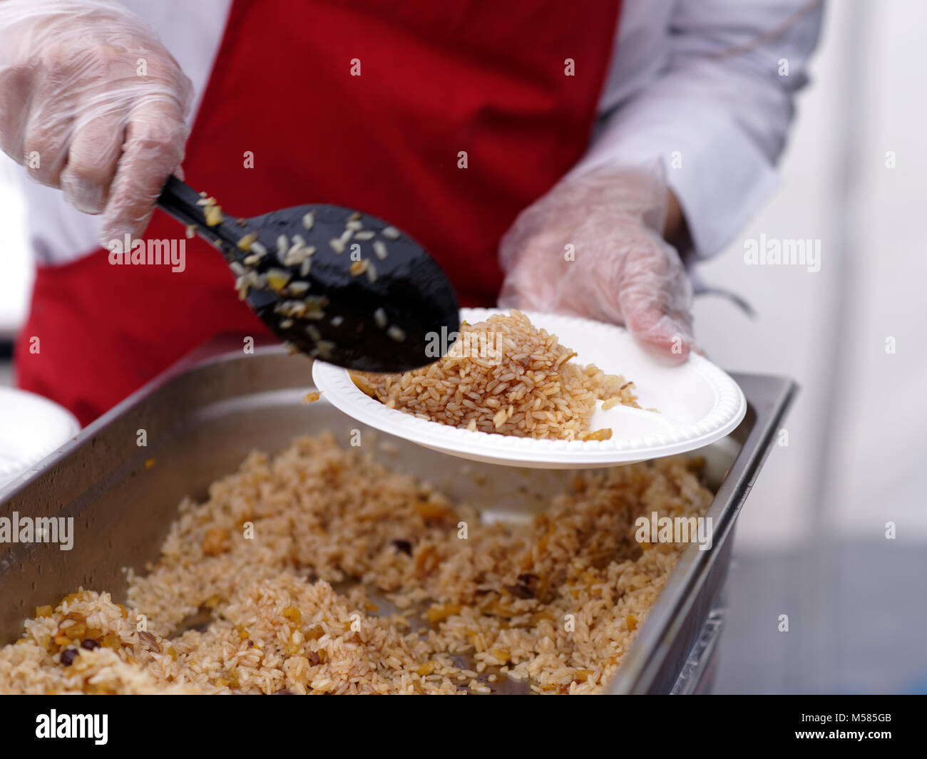 Serving pilaf outdoors during a party Stock Photo